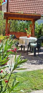 a patio with a table and bench and a gazebo at Garden City Apartment in Cluj-Napoca +4 photos