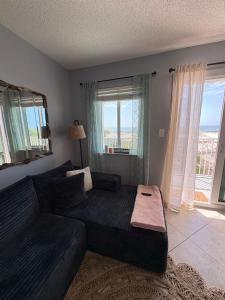 a living room with a couch and a large window at Stay beachy in Gulf Shores