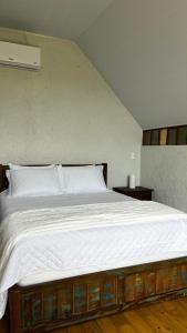 a bedroom with a large bed with white sheets at cabana refúgio in Paulo Lopes
