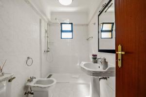 a white bathroom with a toilet and a sink at Villa Vineyard by Homie in Câmara de Lobos +35 photos
