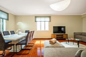 a living room with a table and a television at Villa Vineyard by Homie in Câmara de Lobos