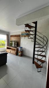 a living room with a spiral staircase in a house at cabana refúgio in Paulo Lopes +6 photos