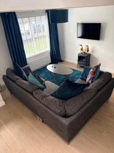 a living room with a couch and a table at 1 Shiphouse Apartment in Lamlash