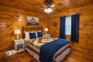 a bedroom with a bed and a ceiling fan at Wilderness Lodge, Hot Tub, Pool Table, Pool Access, WIFIeach paid day in Sevierville +41 photos