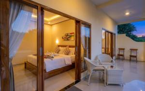 a bedroom with a bed and a table and chairs at Bali Nusa Cottage in Nusa Lembongan +12 photos