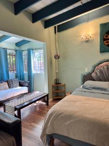 a bedroom with a bed and a couch in it at Baja Beach House Pools, Beaches & Ocean View in San Antonio del Mar +80 photos