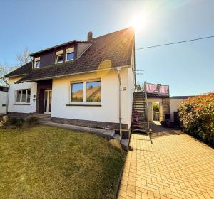 a white house with a roof and a brick driveway at Chalet Annemie in Mendig