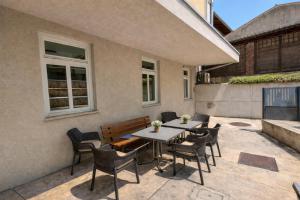a patio with a table and chairs and a bench at Mediterranean Rooms Koper in Koper