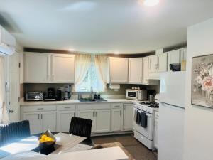 a kitchen with white cabinets and a table and a sink at Dafna, Unit 3 - Two Bedroom, One Bath in Cromberg