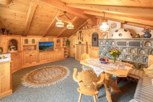 a kitchen with a table and a tv in a room at Ferienwohnung ZUGSPITZE in Krün