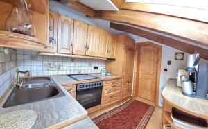 a kitchen with wooden cabinets and a sink at Ferienwohnung ZUGSPITZE in Krün