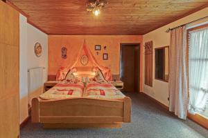 a bedroom with a large bed with a wooden ceiling at Ferienwohnung HERZOGSTAND in Krün