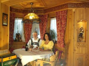 a man and a woman sitting at a table at Ferienwohnung KARWENDEL in Krün
