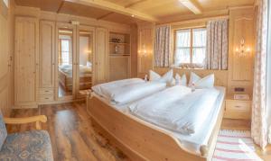 a bedroom with a large bed with white sheets at Ferienwohnung KARWENDEL in Krün