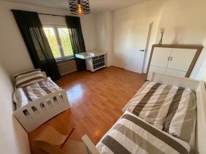 two beds in a room with a wooden floor at Chalet Annemie in Mendig