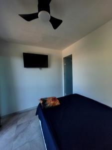 a bedroom with a ceiling fan and a bed at Pousada Terraço do Peró Cabo Frio Há 200 metros da Praia in Cabo Frio