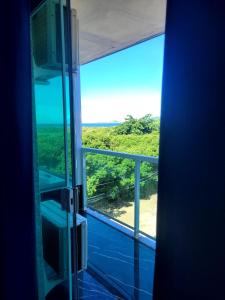 a room with a large window with a view at Pousada Terraço do Peró Cabo Frio Há 200 metros da Praia in Cabo Frio