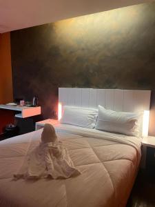a baby in a robe sitting on a bed at BlackView in Kota Kinabalu