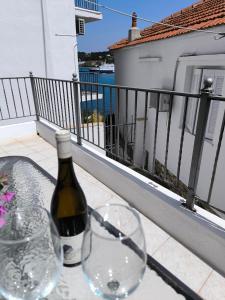 a bottle of wine and two glasses on a balcony at Reborn Project Plakes in Skiathos