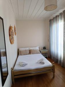 a bedroom with a bed with two towels on it at Reborn Project Plakes in Skiathos