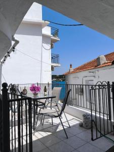a patio with a table and chairs on a balcony at Reborn Project Plakes in Skiathos