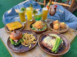 a wooden table topped with plates of food and drinks at Voodoo House in Lalao
