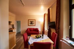 a living room with a table and a red couch at HEINRICHs winery bed & breakfast in Langenlonsheim