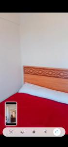 a bed with a red and white bed frame at ريم الفلا in Dawwār Abū Maḩrūs