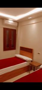 a bedroom with a bed with a red rug at ريم الفلا in Dawwār Abū Maḩrūs