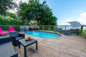 a pool on a deck with chairs and a table at 2-3 personnes - Vue Mer et Piscine - Anse à l Âne - trois Îlets - Plage 2 min en voiture in Les Trois-Îlets