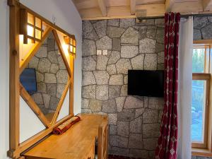 a room with a stone wall with a mirror at Montvale Resort in Pasu