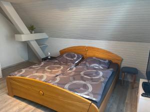 a bed with a wooden frame in a room at Gästezimmer Polster in Birstein