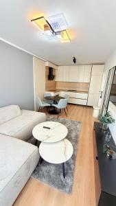a living room with a couch and two tables at TRIO Sun Class Park Residence in Târgovişte