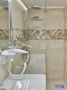 a bathroom with a shower and a sink and a toilet at Pensiunea Iris in Băile Tuşnad +37 photos
