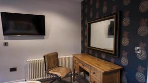 a bathroom with a mirror and a chair and a desk at The Gregory Arms in Harlaxton