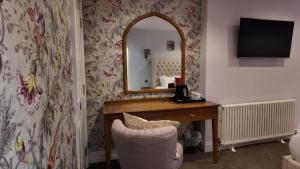 a bedroom with a desk and a mirror and a chair at The Gregory Arms in Harlaxton +32 photos