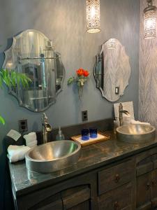 a bathroom with two sinks and two mirrors at Riverhouse Hidden Gem in The Dalles