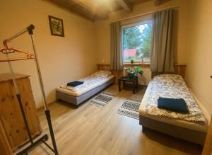 a living room with two beds and a window at DOM NA WYŁĄCZNOŚĆ- Odpoczynek w sercu Mazur in Miłki