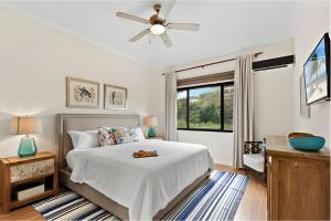 a bedroom with a bed and a ceiling fan at Pacific Beach 9 - Beachfront Condo, BBQ, pool, prime location, sleeps 4 in Potrero