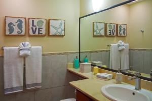 a bathroom with a sink and a mirror at Pacific Beach 9 - Beachfront Condo, BBQ, pool, prime location, sleeps 4 in Potrero +22 photos