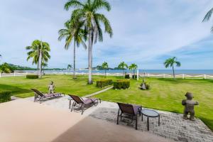 a park with palm trees and chairs and the ocean at Pacific Beach 9 - Beachfront Condo, BBQ, pool, prime location, sleeps 4 in Potrero