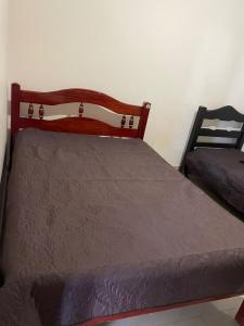 a bed in a bedroom with a wooden head board at Recanto Chaparral in Aragoiânia +13 photos