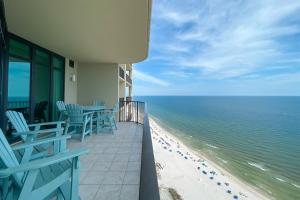 a balcony with chairs and a view of the beach at Phoenix West 2207 Upscale Luxury Updated Beachfront Waterslide-Lazy River in Orange Beach