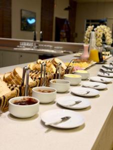 a buffet with white plates and food on a table at Harry World Parque Hotel in Curitibanos