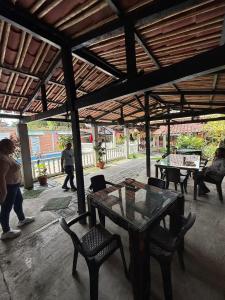 a patio with a table and chairs and people walking at La morada in Guayabal