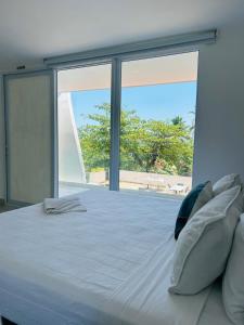 a bedroom with a large bed with a large window at The Views Resort in El Zonte