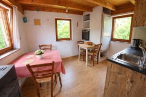 a kitchen and dining room with a table and chairs at Glamping Volčji tabor - zavetje tišine sredi gozda in Gornja Voća