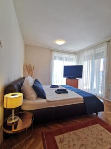 a bedroom with a large bed with a flat screen tv at Kovács Apartmanház in Balatonfüred