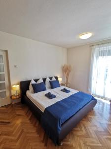 a bedroom with a large bed with blue sheets at Kovács Apartmanház in Balatonfüred