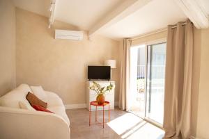 a living room with a white couch and a tv at Casa Mamou in Cavaillon +28 photos